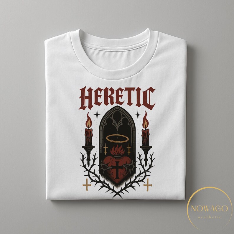 May include: White t-shirt with a gothic design featuring the word "HERETIC" in red, a heart with a cross, candles, and a halo. The design is framed by thorns and crosses, creating a dark aesthetic.