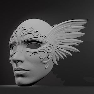 May include: A gray, sculpted mask with a human face, adorned with intricate floral and scrollwork designs. The mask features a prominent wing on the right side, adding a dramatic flair. The mask is likely for costume or decorative purposes.