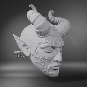 May include: A 3D-printed, light gray mask of a horned creature with pointed ears and closed eyes. The mask features detailed horns, facial features, and vine-like embellishments. The text "Layerl 3D Print" is visible on the left side.