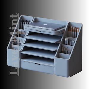 Puede incluir: Un organizador de escritorio gris claro con múltiples compartimentos y estantes. Cuenta con ranuras para bolígrafos y pinceles, un cajón y un estante que sostiene una computadora portátil. El diseño es moderno y minimalista, ideal para suministros de oficina o arte.