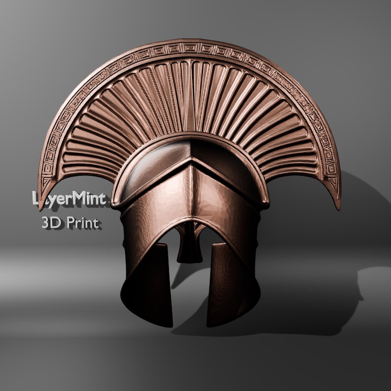 Puede incluir: Un casco espartano de color bronce con una cresta y una protecci&oacute;n facial detalladas. El casco tiene un acabado pulido y est&aacute; sobre un fondo gris. El texto "LayerMint 3D Print" es visible en el lado izquierdo.