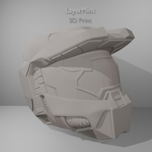 May include: A light gray 3D-printed helmet with a futuristic design. The helmet features angular shapes, a visor area, and the text "LayerMint 3D Print". The overall aesthetic suggests a science fiction or gaming theme.