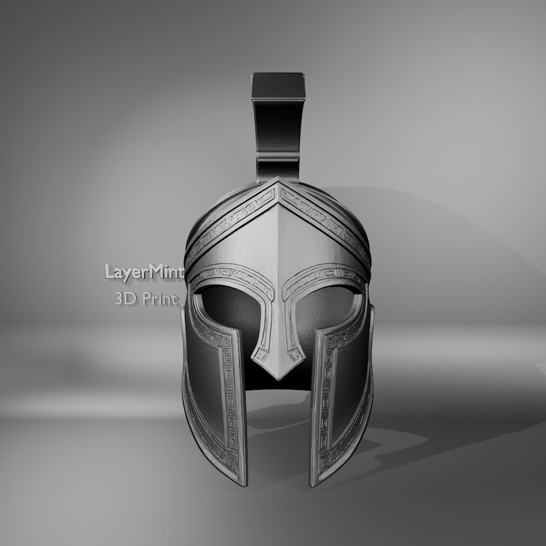 K&ouml;nnte beinhalten: Ein silberfarbener spartanischer Helm mit hohem, rechteckigem Kamm. Der Helm weist detaillierte Gravuren um die Augenbrauen und Wangen auf, und der Text "LayerMint 3D Print" ist auf der Seite sichtbar.