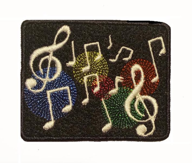 May include: Black rectangular patch featuring embroidered musical notes and symbols. A large white treble clef and musical notes are on the left. Colorful circles in blue, yellow, red, and green surround the notes. A music-themed patch.