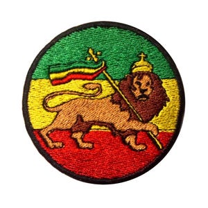 Può includere: Toppa ricamata circolare con un leone che tiene un'asta e una bandiera nei colori rosso, giallo e verde. Il leone indossa una corona ed è posto su uno sfondo bordato di nero. Per abbigliamento o accessori.