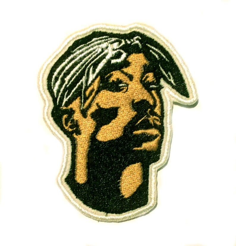 May include: Embroidered patch depicting a portrait of a man wearing a bandana. The patch is in black and gold, with a white border. The design is a stylized representation of the subject's face.