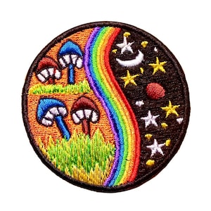 Può includere: Toppa ricamata circolare con un disegno a forma di arcobaleno, funghi, stelle e una luna crescente. La toppa ha un bordo nero ed è realizzata con filo colorato. Il design è diviso in temi giorno e notte.