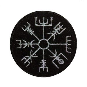 Può includere: Toppa rotonda nera con un simbolo Vegvisir bianco ricamato, una bussola vichinga. Il simbolo ha otto bracci che si irradiano da un punto centrale. La toppa è circolare e ha un bordo nero.