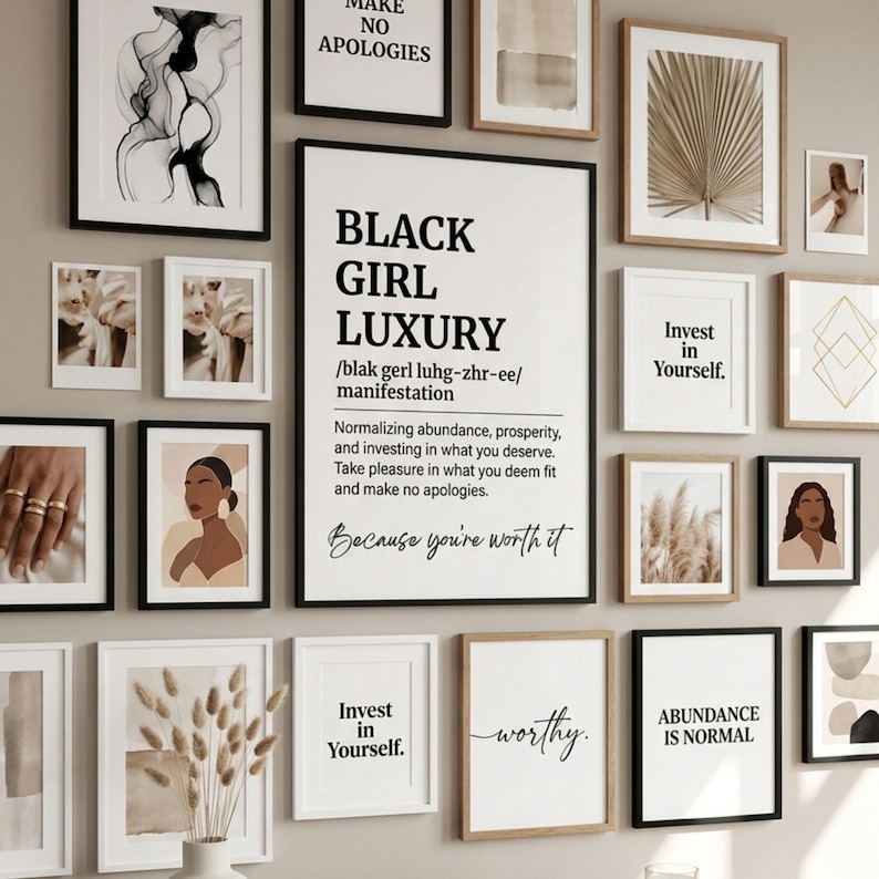 May include: A gallery wall arrangement featuring various framed prints, including a central poster with the text Black Girl Luxury, definition, and manifestation, alongside prints with phrases like Invest in Yourself and Abundance is Normal.