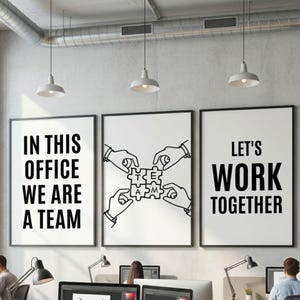 Può includere: Tre poster incorniciati con cornici nere sono appesi a una parete. Il poster di sinistra recita "IN THIS OFFICE WE ARE A TEAM". Il poster centrale mostra mani che assemblano pezzi di puzzle. Il poster di destra dice "LET'S WORK TOGETHER".