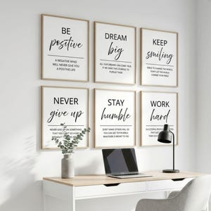 May include: A set of six rectangular wall art prints with white backgrounds and black text featuring motivational phrases including Be Positive, Dream Big, Keep Smiling, Never Give Up, Stay Humble, and Work Hard, arranged in two rows of three.