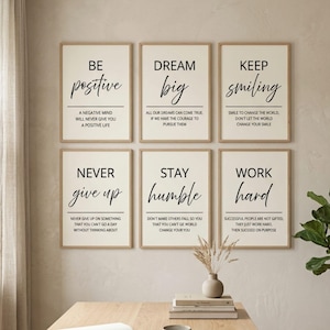 May include: A set of six rectangular wall art prints in light wood frames, each featuring black text on a cream background with motivational quotes including Be positive, Dream big, Keep smiling, Never give up, Stay humble, and Work hard.