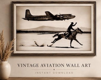 Op de afbeelding: Een ingelijste wandkunstprint in sepia-tinten met een vintage propellervliegtuig dat laag over een woestijnlandschap vliegt, terwijl een persoon op de voorgrond op een galopperend paard rijdt, wat een contrast vormt tussen luchtvaart en paardrijden.