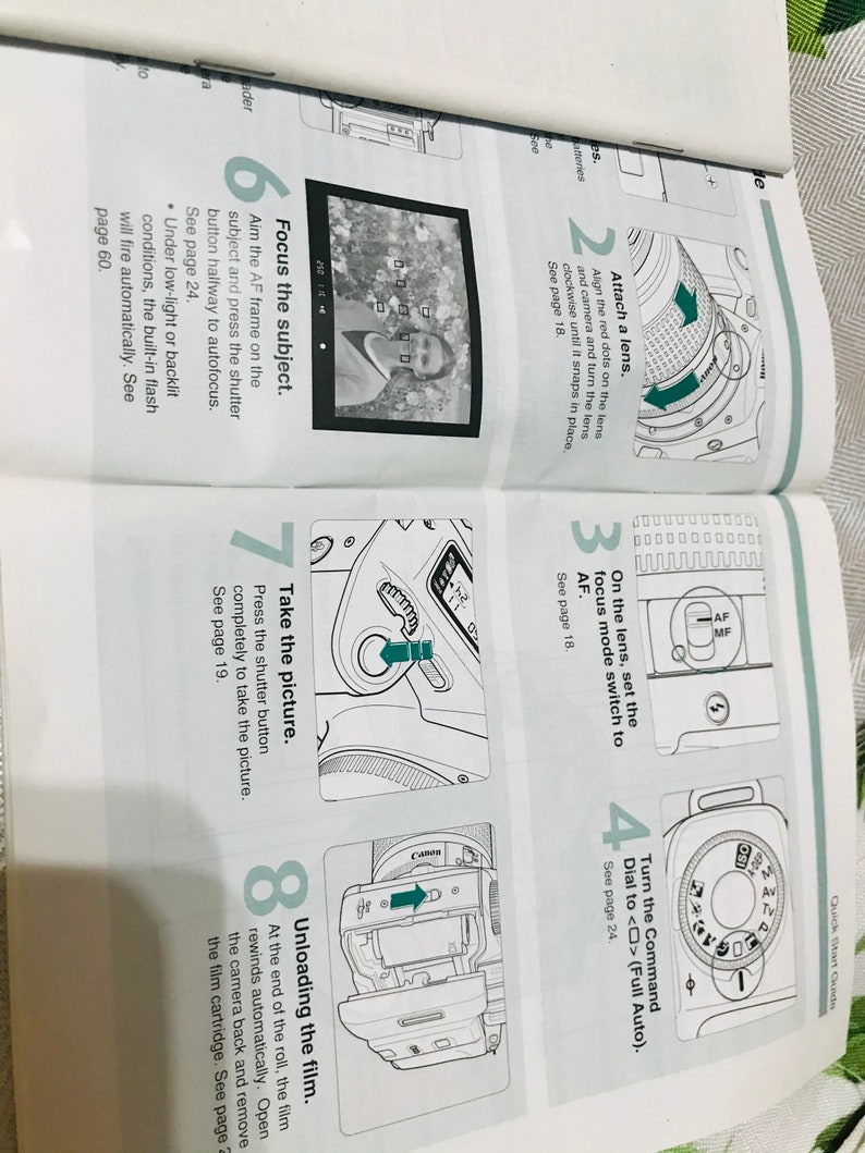 May include: A black and white illustrated guide with instructions on how to use a Canon camera. The guide shows how to attach a lens, set the focus mode, turn the command dial, focus the subject, take the picture, and unload the film.