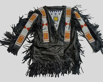 May include: Black leather jacket with long sleeves and fringe detailing. The jacket features decorative beaded panels in white, red, and yellow. The design includes geometric patterns and a triangular yoke. A traditional Native American style garment.