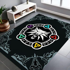 Puede incluir: Alfombra rectangular negra con un emblema de cabeza de lobo blanco rodeado de formas y s&iacute;mbolos geom&eacute;tricos coloridos. La alfombra tiene un borde decorativo con un dise&ntilde;o gris y blanco. La alfombra est&aacute; sobre un suelo de baldosas grises.