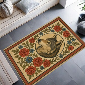 May include: Rectangular beige doormat featuring a detailed illustration of a wolf's head within a floral wreath of red roses and blue flowers. The mat has a brown border and is suitable for indoor or outdoor use.