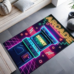 Könnte beinhalten: Ein neonrosa, blauer und gelber Arcade-Spielteppich mit dem Wort "ARCADE" in neongelben Buchstaben. Der Teppich zeigt ein Retro-Arcade-Spiel mit einem Bildschirm, auf dem "START" in neongelben Buchstaben steht.