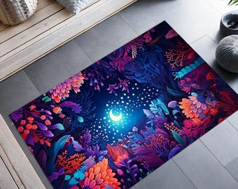 Può includere: Un tappeto colorato con una luna crescente e stelle al centro, circondato da fiori e foglie vibranti. Il tappeto ha uno sfondo blu scuro e presenta una varietà di sfumature di rosa, viola e verde.