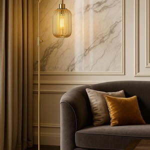 May include: A tall floor lamp with a slender brass-toned metal stand and a circular base. The lamp features an adjustable arm and a cylindrical, vertically ribbed glass shade that emits a warm, glowing light from an internal bulb.