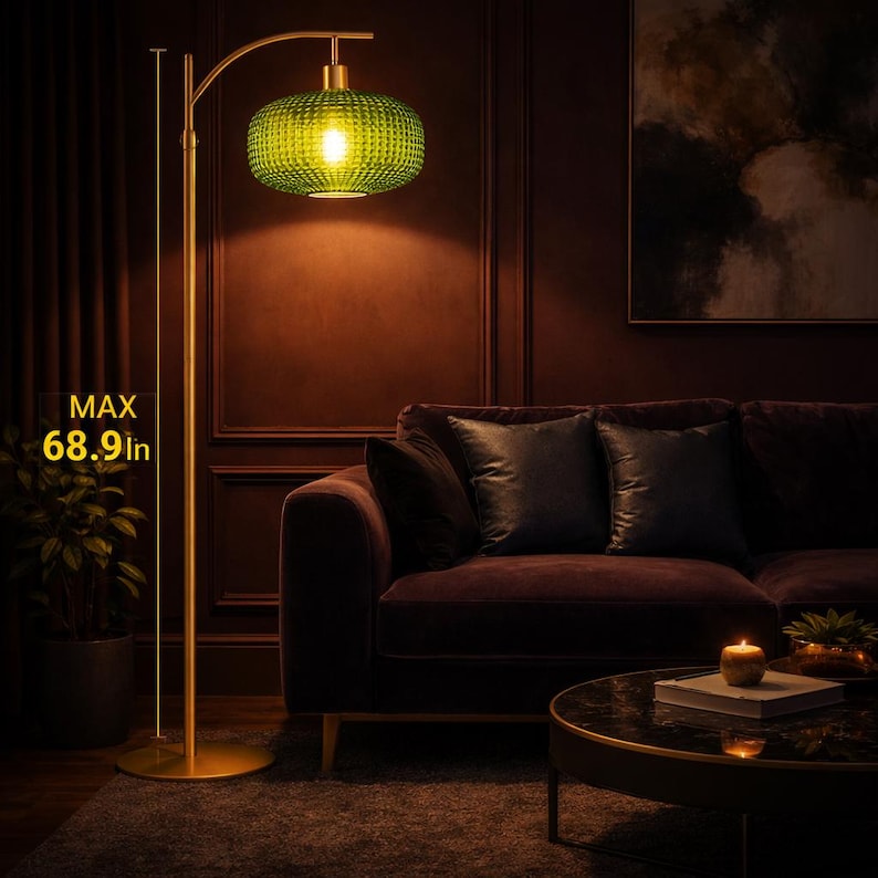 May include: A gold-colored floor lamp with a green glass shade. The shade has a textured pattern and is lit from within. The lamp's maximum height is 68.9 inches. The lamp is in a living room setting with a sofa and coffee table.