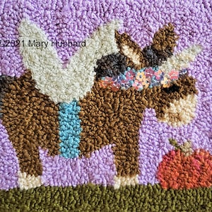 May include: A brown and white plush toy horse with a blue and white saddle and a sparkly pink and blue headband. The horse is standing on a purple background with a red apple in the foreground. ©2021 Mary Hubbard