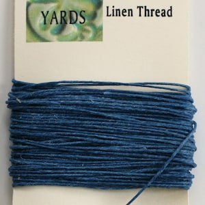 May include: A spool of 4-ply Irish waxed linen thread in a deep blue color. The spool is labeled "10 YARDS".