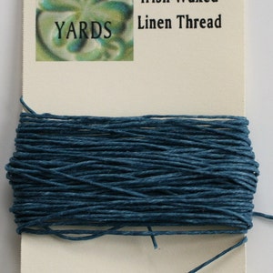 May include: A spool of 10 yards of 4-ply Irish waxed linen thread in a deep blue color. The thread is wrapped around a white card with the text "10 YARDS" and "4-ply Irish Waxed Linen Thread" printed on it.