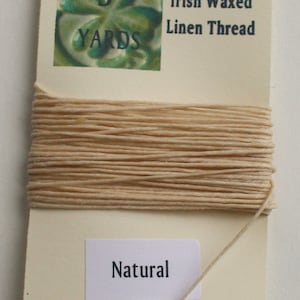 May include: A spool of 4-ply Irish waxed linen thread in natural color. The spool is labeled with "5 yards" and "4-ply Irish Waxed Linen Thread".