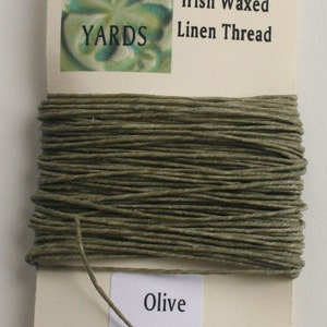 May include: A spool of 10 yards of 4-ply Irish waxed linen thread in olive green. The spool is labeled with the length, type of thread, and color.