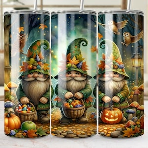 May include: A stainless steel tumbler with a whimsical autumn scene featuring three gnomes. Each gnome wears a green hat and holds a basket of treats or a pumpkin. The design includes autumn leaves, mushrooms, and owls.