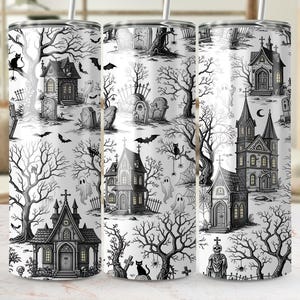 May include: A white tumbler with a black and white Halloween-themed design. The design features haunted houses, tombstones, bats, ghosts, and bare trees. The tumbler has a straw and is suitable for cold beverages.
