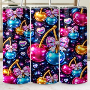 May include: Three stainless steel tumblers featuring a repeating pattern of cherries, bows, and hearts. The cherries are pink, gold, and blue, with glittery bows and diamond accents against a dark, quilted background. Each tumbler has a straw.