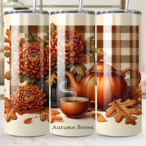 May include: A stainless steel tumbler with an autumn-themed design. The design features orange chrysanthemums, a teapot, a teacup, and fall leaves. The words "Autumn Brews" are printed on the tumbler.
