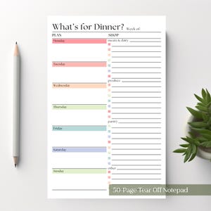 May include: A white paper notepad titled What's for Dinner? with a weekly meal planner section featuring colored bars for each day from Monday to Sunday and a shopping list section with categories for meats and dairy, produce, pantry, and other items.