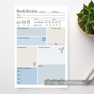 May include: A white 50-page tear-off notepad designed for book reviews. It includes sections for title, author, genre, and ratings, alongside spaces for notes on characters, plot, and favourite moments. A plant and pencils are in the background.