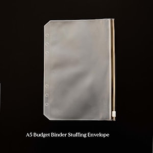 May include: A clear A5 budget binder stuffing envelope with a gold zipper and white zipper pull. The envelope has multiple holes for binder rings and the text "A5 Budget Binder Stuffing Envelope" is printed at the bottom.