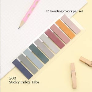 May include: A set of 200 sticky index tabs in 12 trending colors, arranged in a row on a clear backing. The tabs feature a palette of muted tones including blue, gray, teal, mauve, pink, and orange. Text reads 200 Sticky Index Tabs and 12 trending colors per set.