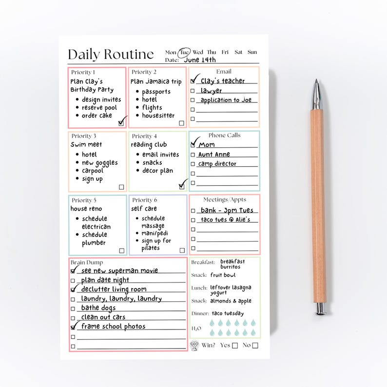 May include: A white daily routine planner notepad with colorful grid sections for priorities, email, phone calls, meetings, and a brain dump list, featuring handwritten tasks and checkmarks, accompanied by a light wood-toned mechanical pencil.