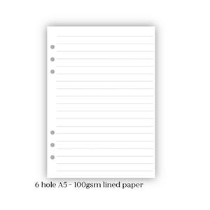 May include: A white A5-sized lined paper sheet with six holes for binders. The paper has horizontal lines and the text "6 hole A5 - 100gsm lined paper" at the bottom. The paper is designed for note-taking and organization.
