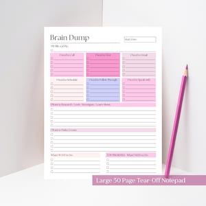 May include: A white notepad titled "Brain Dump" with pink and blue sections for notes. A pink pencil lies on the right. The notepad is labelled "Large 50 Page Tear-Off Notepad".