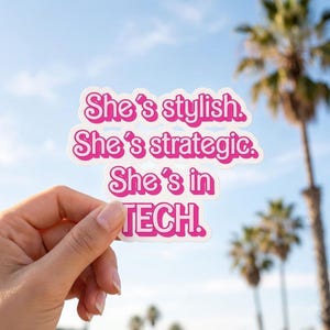May include: A die-cut sticker featuring the text "She's stylish. She's strategic. She's in TECH." in a bold, rounded, hot pink font with a white outline. The lettering is arranged in four stacked lines against a white background.