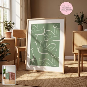 Pode incluir: Uma impressão artística emoldurada com fundo verde sálvia e um padrão repetitivo de linhas brancas representando figuras humanas abstratas. A moldura é de madeira clara com passe-partout branco. Uma etiqueta rosa indica: AVAILABLE IN 3 DIFFERENT COLOR OPTIONS.