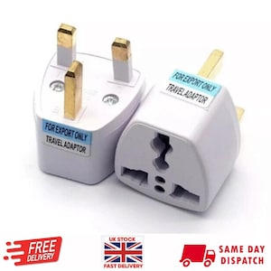 Puede incluir: Dos adaptadores de viaje eléctricos blancos con un enchufe británico de tres clavijas en un extremo y una toma de corriente internacional de tres clavijas en el otro extremo. Los adaptadores tienen una etiqueta azul que dice "FOR EXPORT ONLY TRAVEL ADAPTOR".
