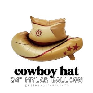 Puede incluir: Un globo de mylar dorado y marrón con forma de sombrero de vaquero. El globo tiene detalles de estrellas rojas y una banda roja. El texto "cowboy hat" y "24" MYLAR BALLOON" está impreso en negro.