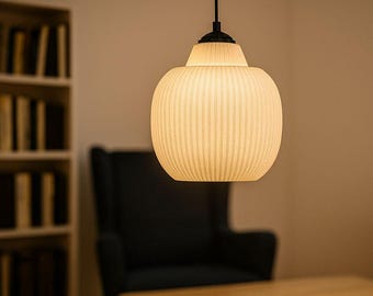 May include: A pendant light fixture with a cream-colored, ribbed shade hangs from the ceiling. The light is spherical with a smaller, cylindrical top. The background includes a bookshelf, a chair, and a table.