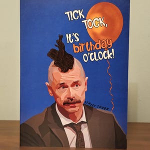 May include: Birthday greeting card with a blue background. It features an illustration of a man with a mohawk and mustache. An orange balloon with the words "TICK TOCK, It's birthday o'clock!" is in the upper right. The words "STREET TOUGH" are in the lower right.