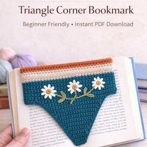 May include: A handmade crochet bookmark in a triangle shape, featuring a teal base with daisy floral embroidery. The top edge has a tan and cream color scheme. The text "Crochet Bookmark Pattern" is visible.