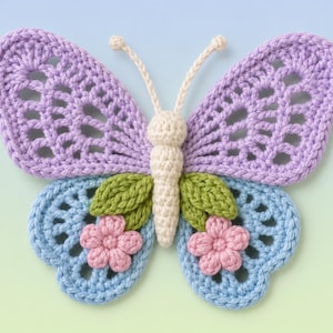 May include: A crochet butterfly applique featuring large lavender upper wings with openwork patterns, smaller light blue lower wings, and a cream-colored body with antennae. Two green leaves and a small pink flower are attached to each lower wing.