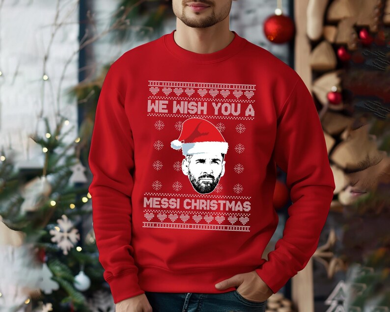 Puede incluir: Jersey navide&ntilde;o rojo con el texto "WE WISH YOU A MESSI CHRISTMAS" en blanco. El jersey presenta un gr&aacute;fico de una persona con un gorro de Pap&aacute; Noel. El jersey es un dise&ntilde;o festivo navide&ntilde;o.